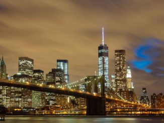 The Brooklyn rie with the famous NYC skyline illuminated in the background