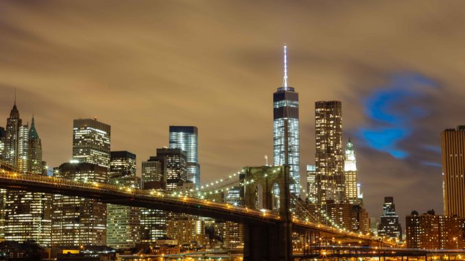 The Brooklyn rie with the famous NYC skyline illuminated in the background