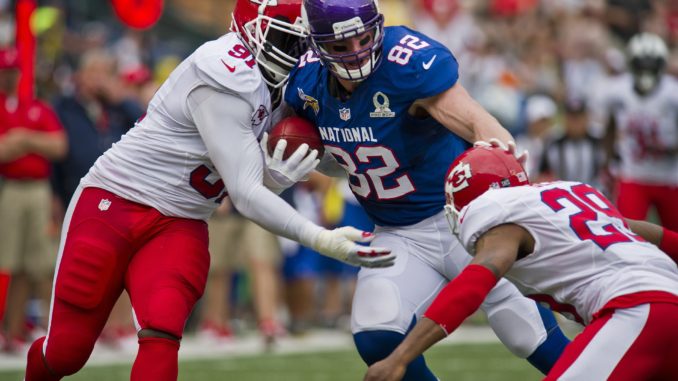 Two players take down their opponent from the opposite team in an NFL match