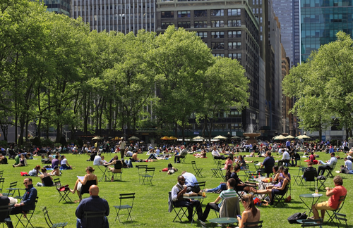 People sitting on chairs and enjoying a nice day in Bryant Park in New York City