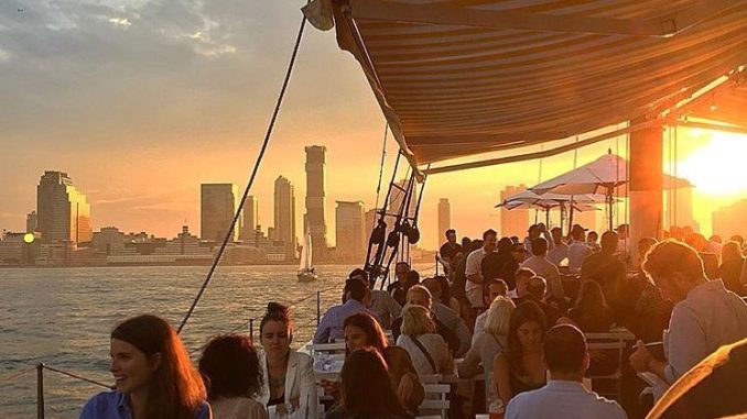 Patrons dining at Grand Banks Oyster Bar located on schooner on the Hudson River.