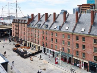 South Street Seaport Museum with ship in background and padestrians walking past shops undernearth