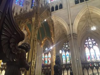 Sun shines through colourful glass into St. Patrick’s Cathedral in Midtown Manhattan, New York City.