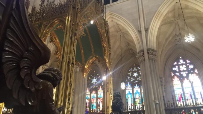 Sun shines through colourful glass into St. Patrick’s Cathedral in Midtown Manhattan, New York City.