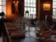 Empty glasses sit on wooden table in front of a portrait, at New York City’s Fraunces Tavern