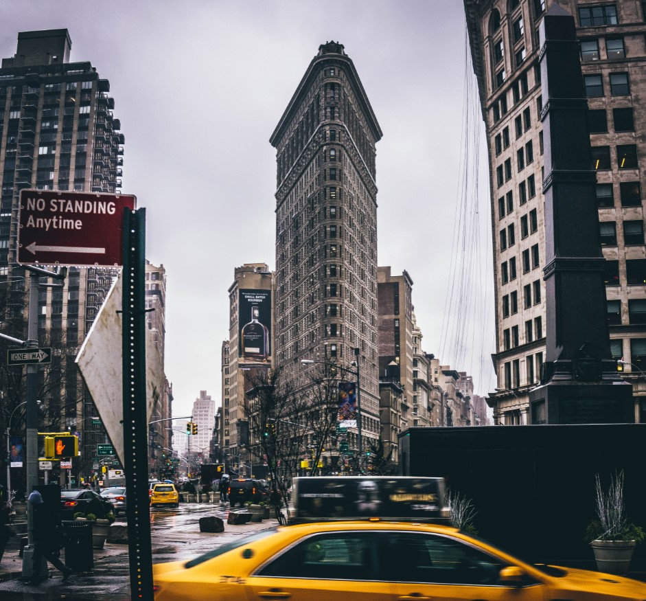 Taxis pass one of New York City’s most unique structures, the Flatiron Building.