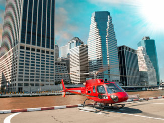 Red helicopter ready to take off in New York summer skyline.