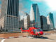 Red helicopter ready to take off in New York summer skyline.