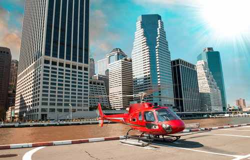 Red helicopter ready to take off in New York summer skyline.