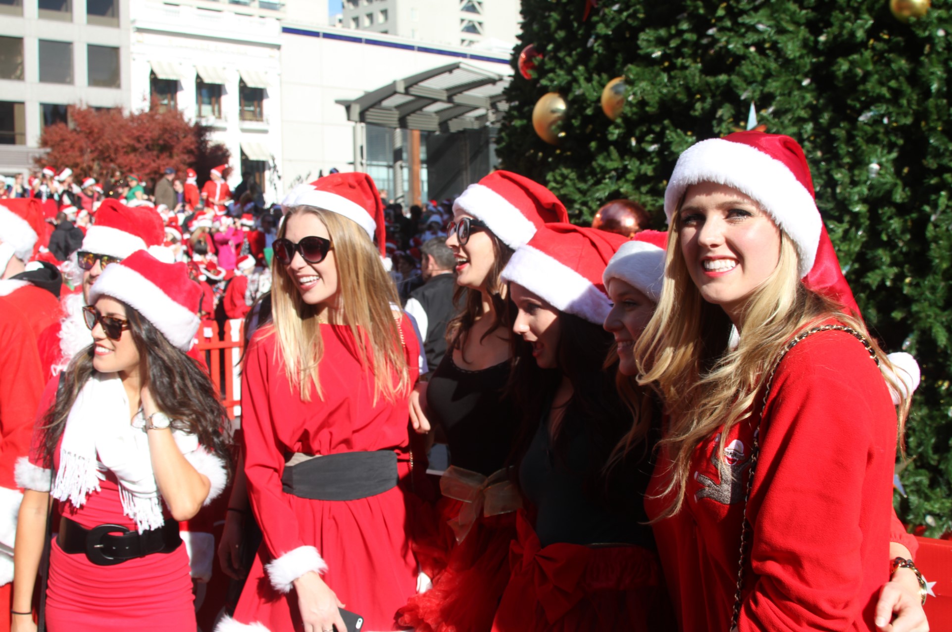 attractive females dressed as santa claus pose for picture