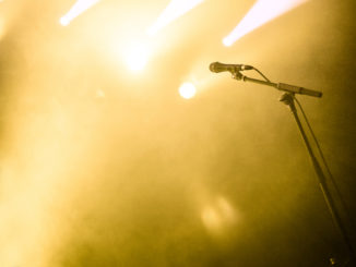 Microphone on empty stage waiting for a voice with copyspace and back light