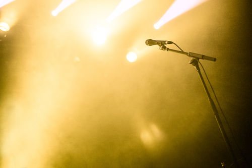 Microphone on empty stage waiting for a voice with copyspace and back light