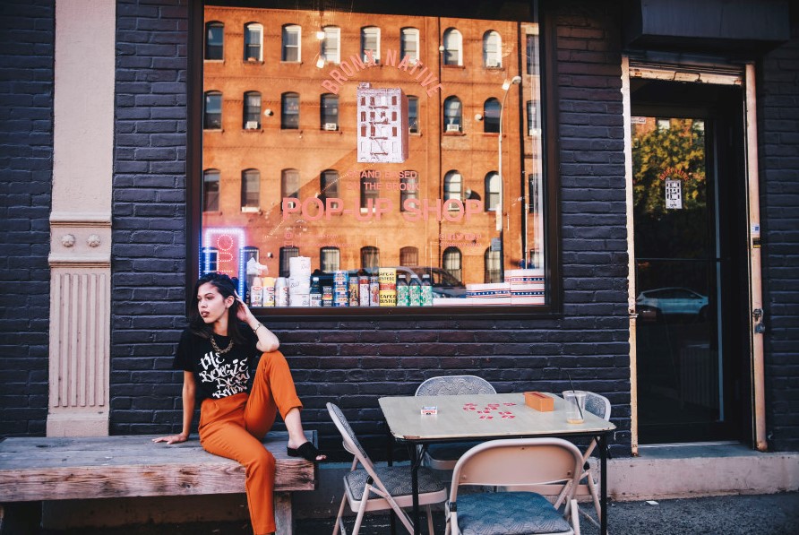 fashionable girl sits outside a pop up shop in the Bronx - new york in december