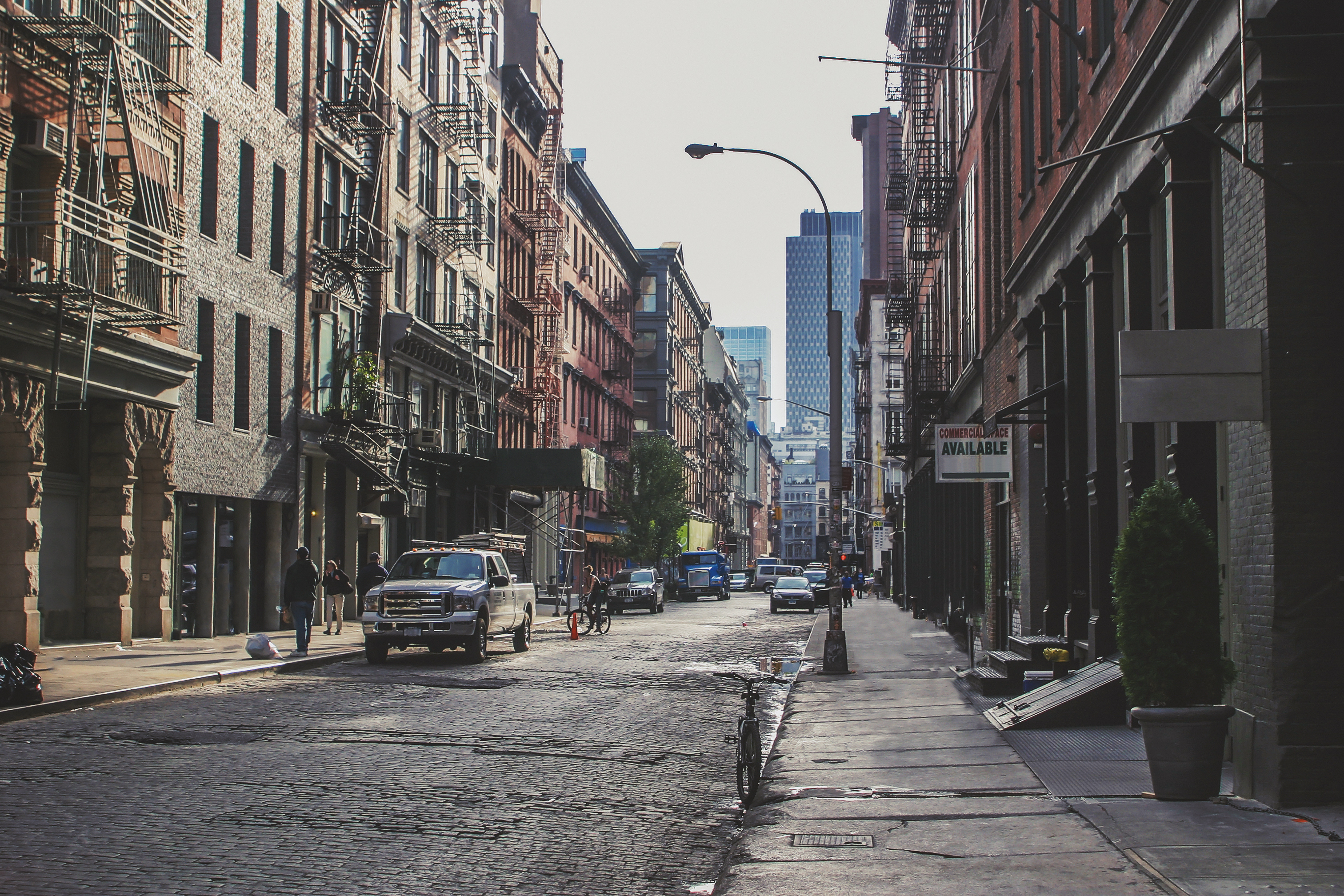 Cars pedestrians and cyclists in a street in Soho NYC