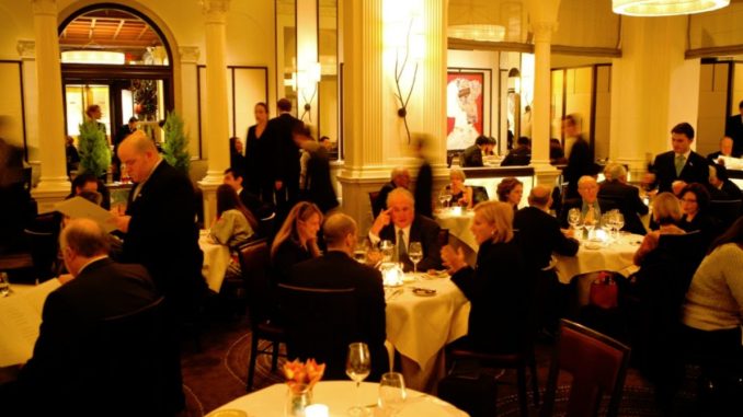 A busy Daniel Restaurant, Manhattan with guests busy chatting and sitting wine