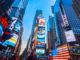 Tall lit up buildings in Times Square NYC