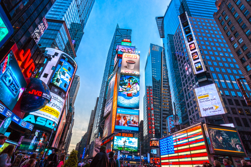 Tall lit up buildings in Times Square NYC