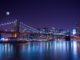New York City's Brooklyn Bridge, at night, under a full moon