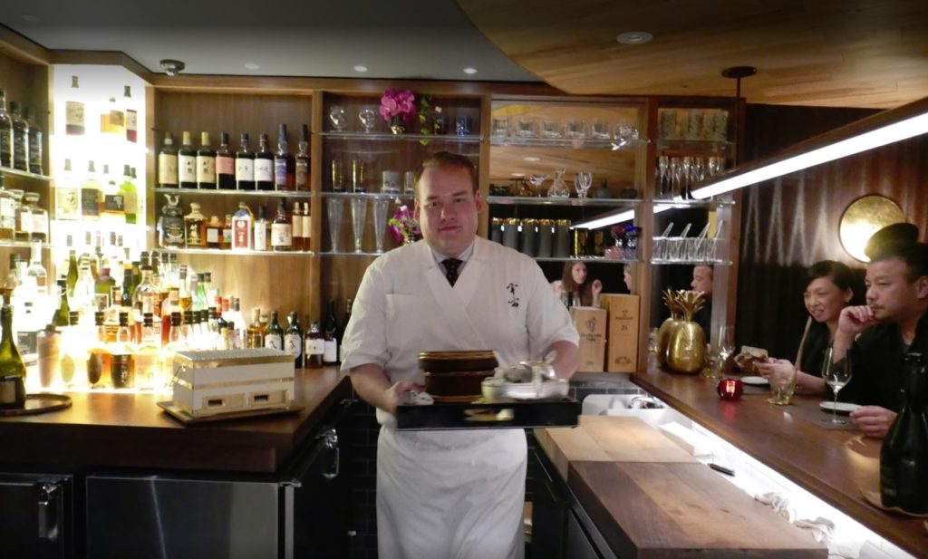 waiter with food ready to serve diners at the uchu sushi bar