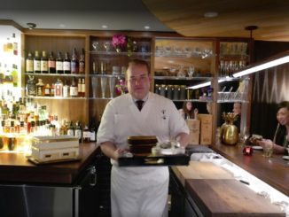 waiter with food ready to serve diners at the uchu sushi bar