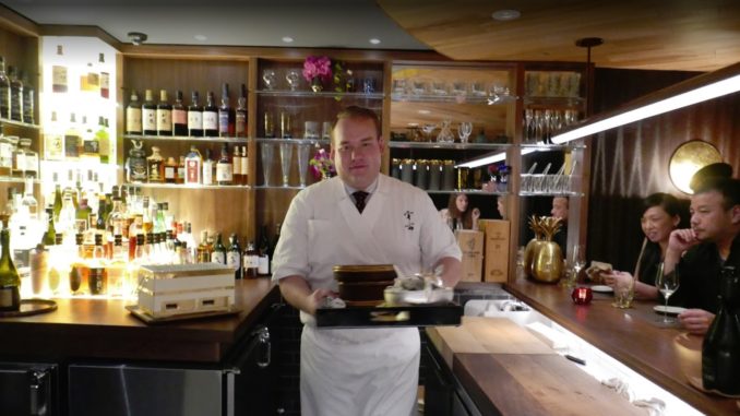 waiter with food ready to serve diners at the uchu sushi bar