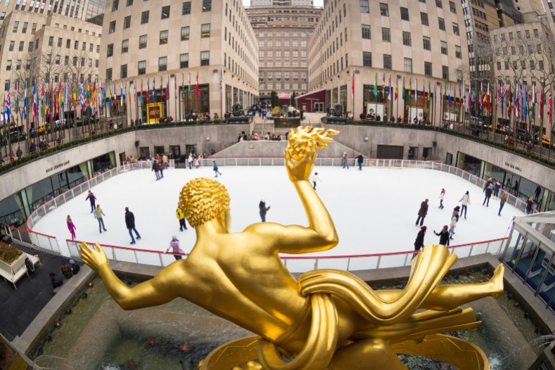 the ice-skating rink behind a gold statue at the Rockefeller Center New York