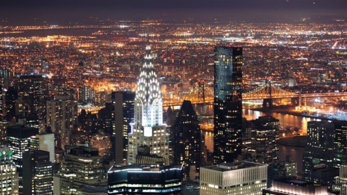 the Chrysler Building, along with the rest of New York, lit up at night