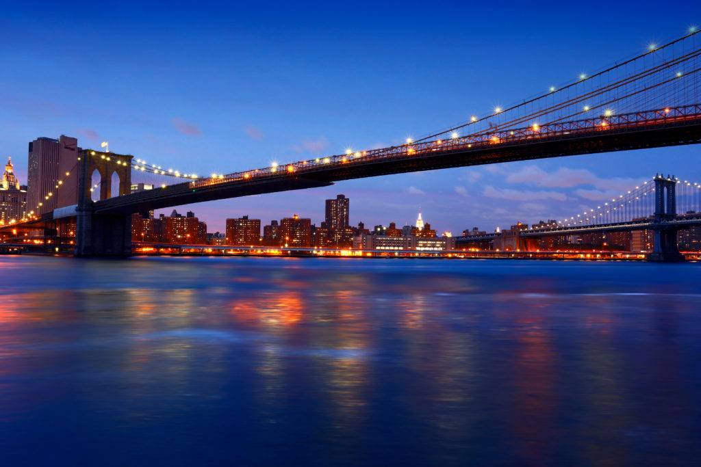 the illuminated Brookly Bridge over hudson river new york dinner cruises