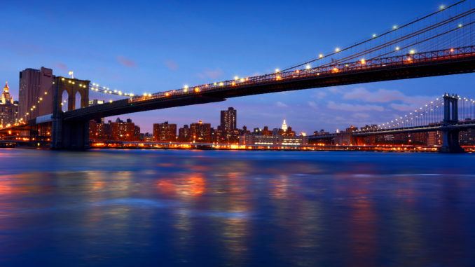 the illuminated Brookly Bridge over hudson river new york dinner cruises