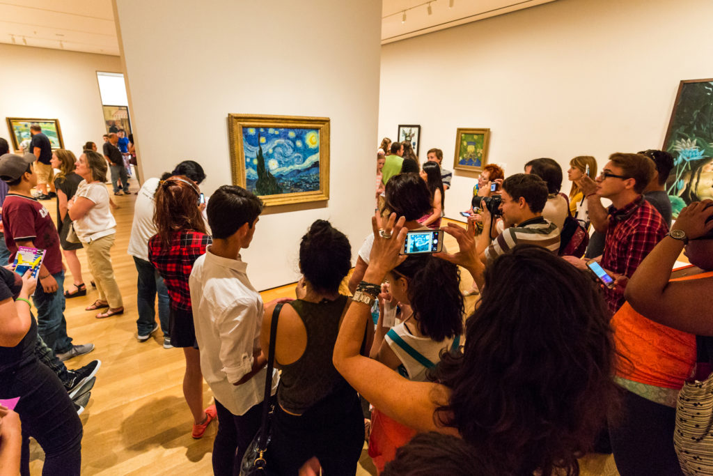 people gather around the work of Vincent Van Gogh at the MoMA in New York