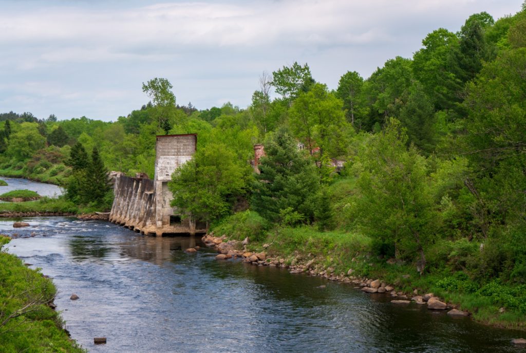 what looks to be part of a broken bridge by the side of the river in adirondack park - national parks in new york