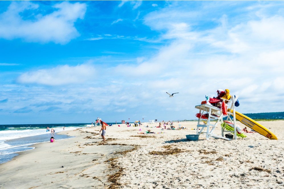 Lifeguard watches sea as people sunbathe on the beach